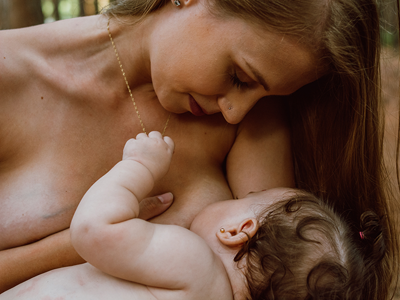 Foto de uma mãe amamentando sua filha bebê.